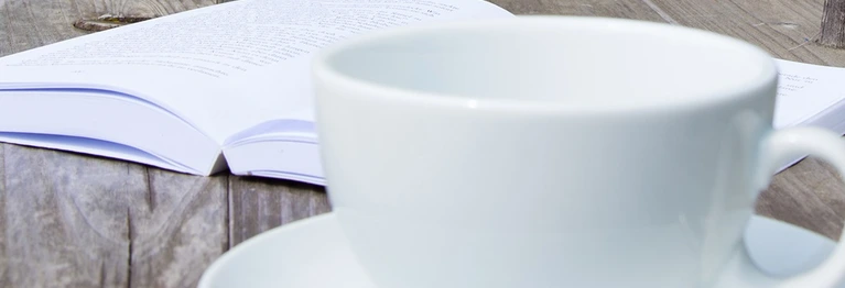 Buch und Kaffeetasse