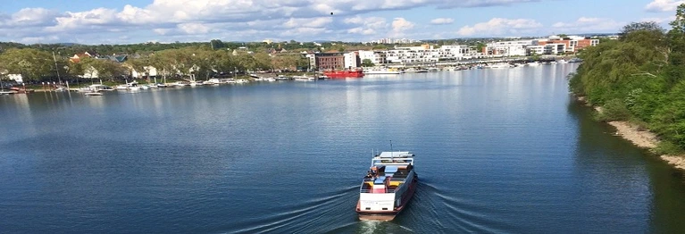 Ein Boot fährt in den Schiersteiner Hafen ein. Blick auf Schierstein