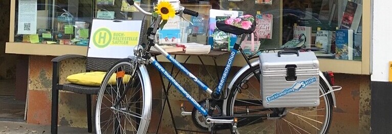 Unser Fahrrad mit unserem Logo vor dem Schaufenster