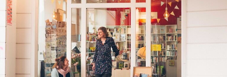 Marietta Bernasconi und Anna Wallitzer stehen vor der Ladentür der Buchhandlung