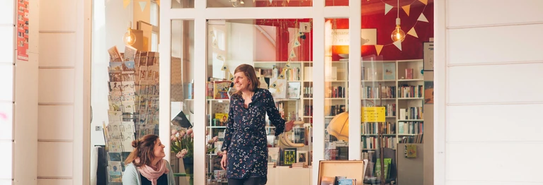 Marietta Bernasconi und Anna Wallitzer stehen vor der Ladentür der Buchhandlung